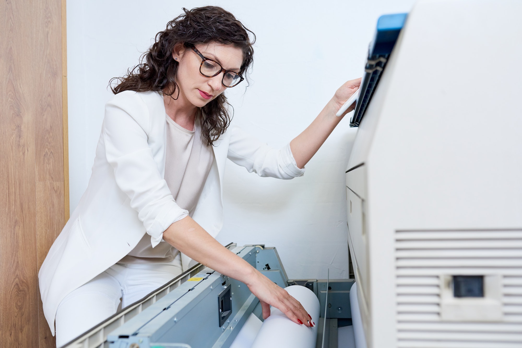 Woman putting paper into printer